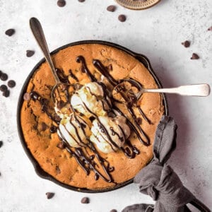Overhead view of chocolate chip skillet cookie with ice cream and chocolate syrup