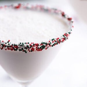 Close up of a sugar cookie martini with Christmas sprinkles on the rim