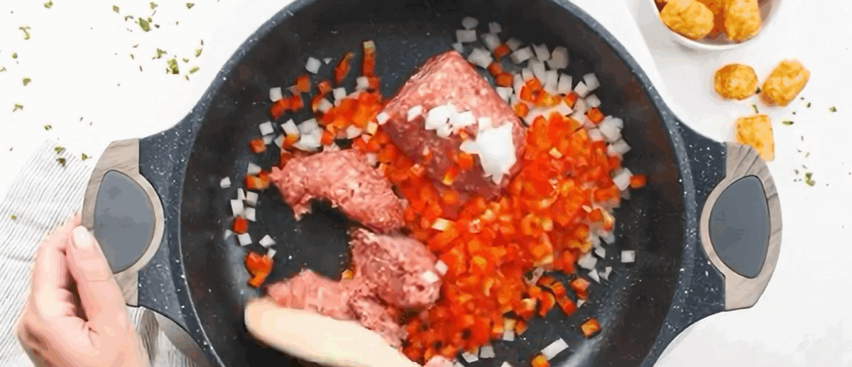 Cooking the sausage and veggies in a pan.