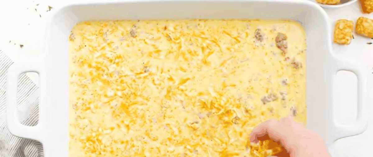 Sprinkling cheese over the casserole.