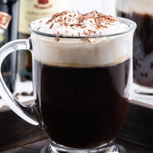 tall glass mug of Irish Coffee garnished with chocolate shavings