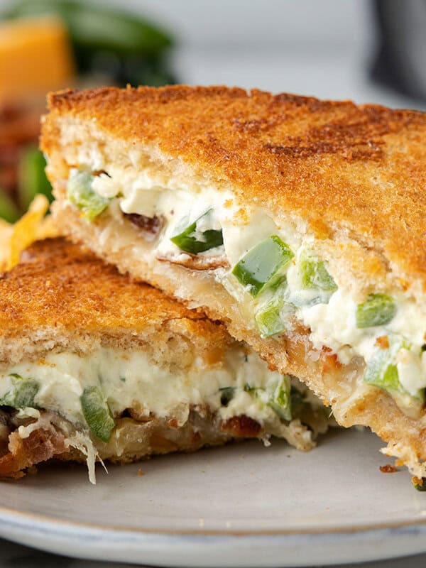 Two halves of a jalapeno popper grilled cheese on top of each other