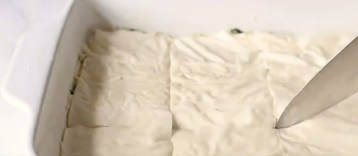 Scoring the spanakopita with a knife.