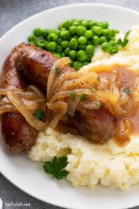 bangers and mash with onion gravy over mashed potatoes close up