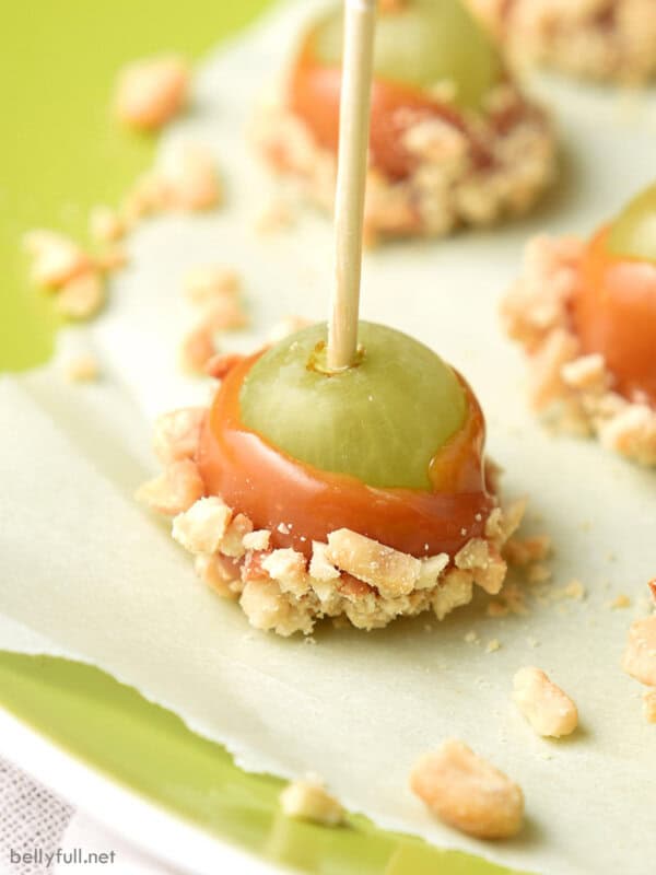 close up caramel apple grapes on green plate