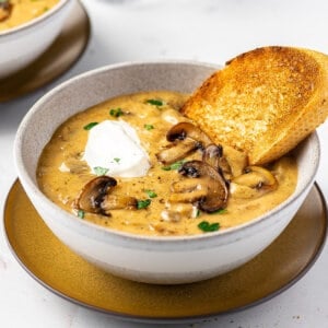 A bowl of Hungarian mushroom soup with a piece of crusty bread
