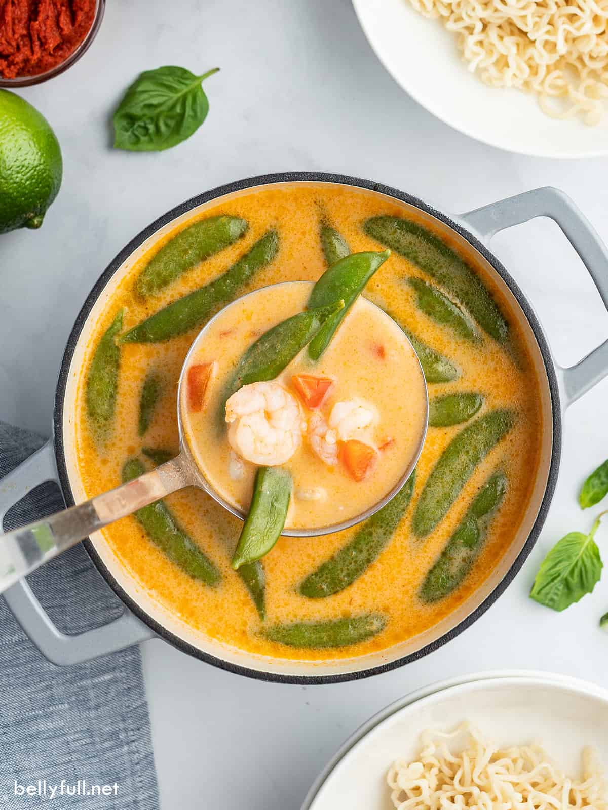 overhead ladle full of Thai Curry Soup in large pot