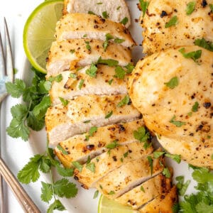 Overhead view of air fryer margarita chicken on a white plate, with one breast cut into slices