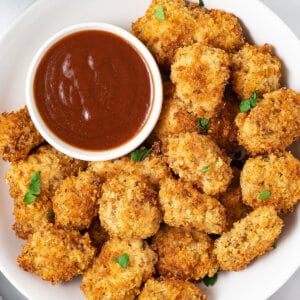 Overhead view of air fryer chicken nuggets on a white plate with a dish of ketchup