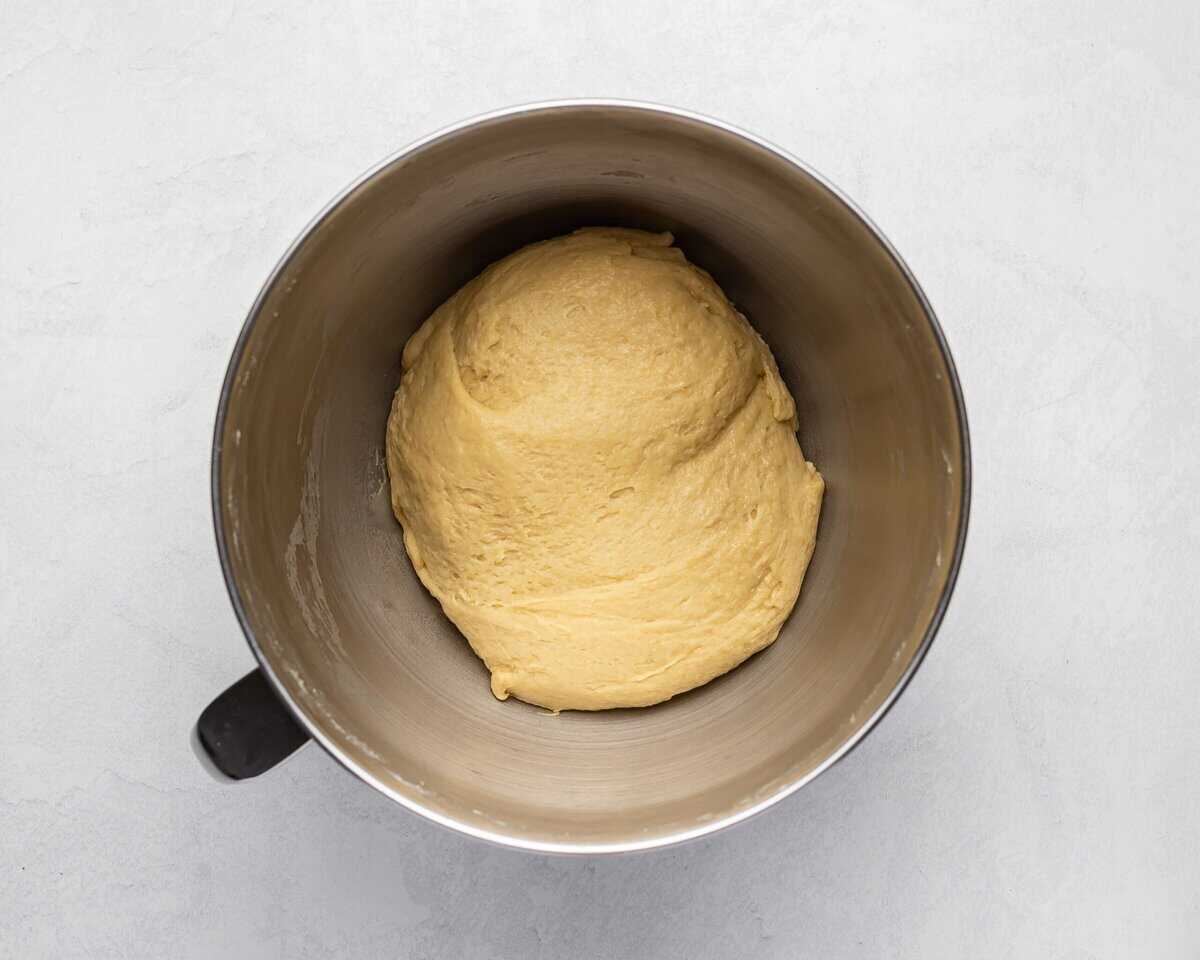 Adding butter to make a cohesive dough ball in the bowl.