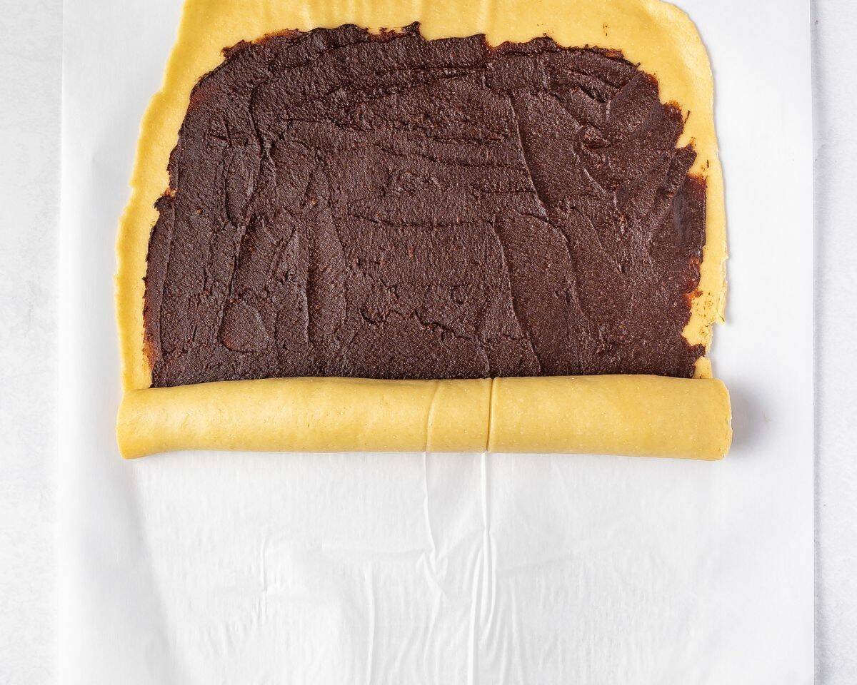 Rolling the dough with the chocolate filling.