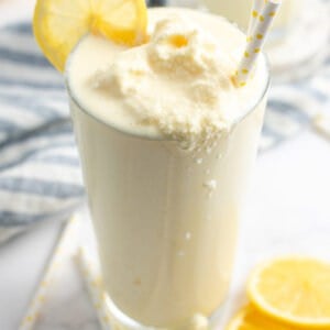 Overhead angled view of a frosted lemonade that's dripping over the edge of the glass