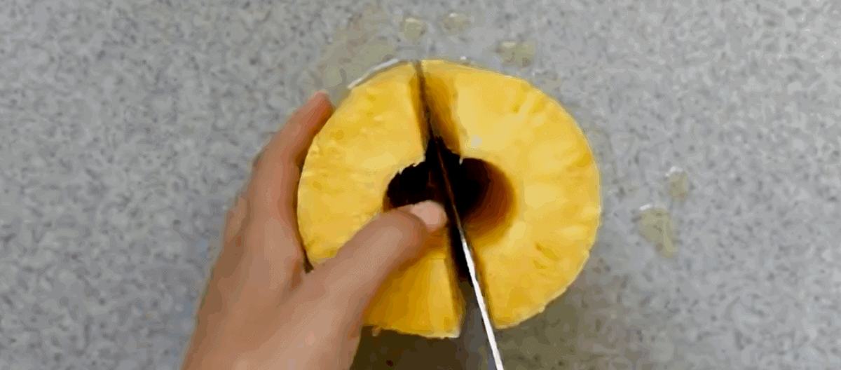 Cutting a peeled pineapple. 