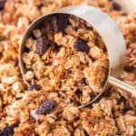 A measuring cup scooping up homemade granola