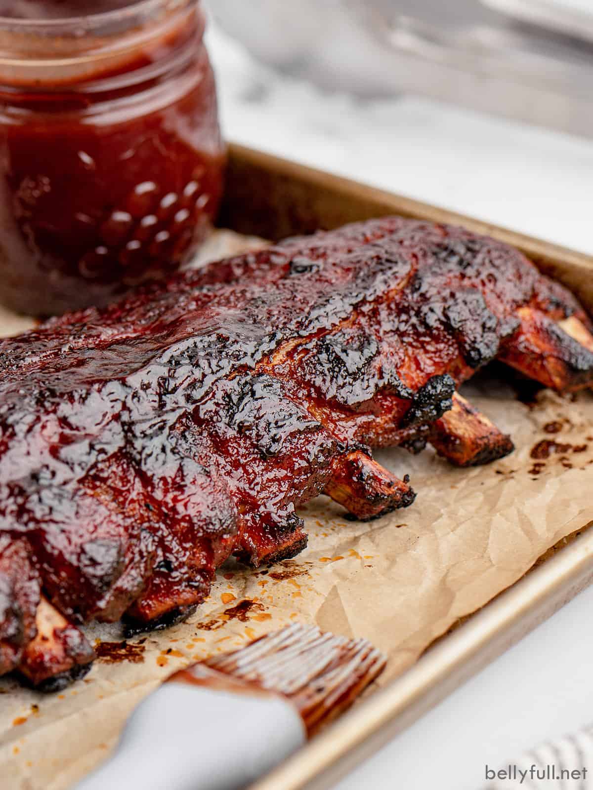 A rack of baby back ribs on a baking sheet