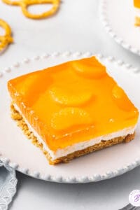 square portion of orange pretzel dessert on white plate