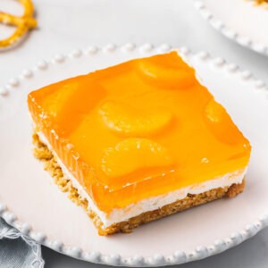 square portion of orange pretzel dessert on white plate
