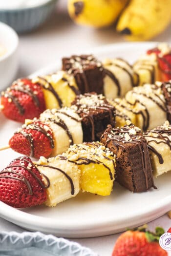 banana split dessert kabobs on white serving platter