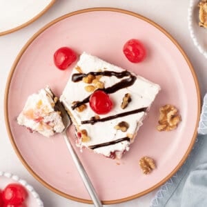 overhead piece of banana split lush dessert on pink plate with fork