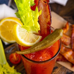 Overhead view of a Bloody Mary garnished with lemon, celery, and bacon