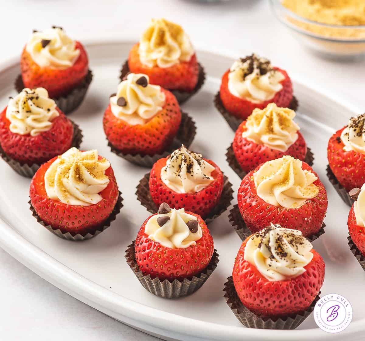 white plate with cheesecake filled whole strawberries