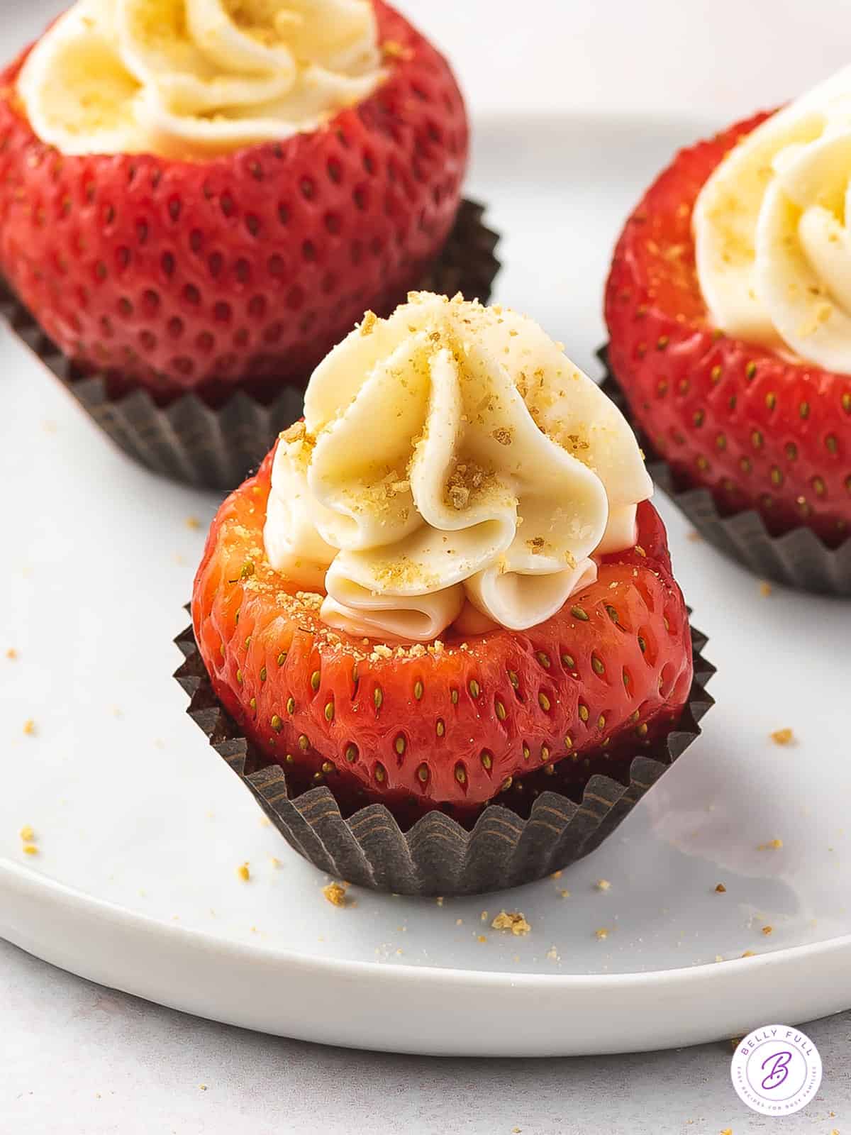 close up cheesecake stuffed strawberry topped with graham cracker crumbs