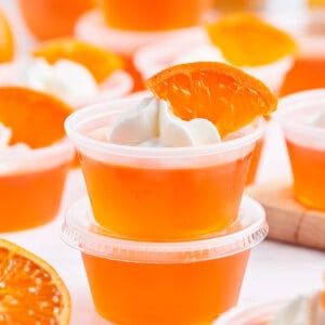 two stacked orange creamsicle jello shots with whipped cream