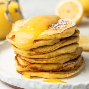 tall stack of lemon ricotta pancakes on white plate
