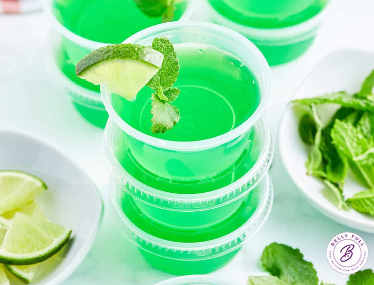 stack of 3 green mojito jello shots garnished with lime wedge