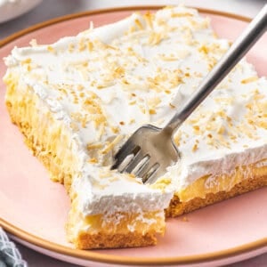 square slice of pineapple lush with piece on fork