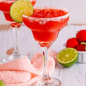 A strawberry margarita garnished with a lime slice