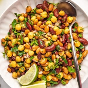 overhead three bean salad in white serving bowl with spoon