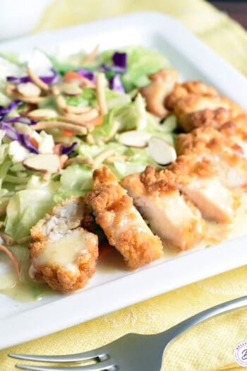 breaded sliced chicken pieces with salad on plate