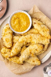 overhead plate of coconut baked chicken tenders with dipping sauce