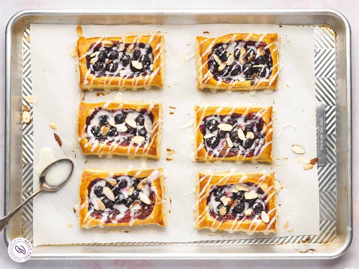 Drizzling the tarts with the glaze.