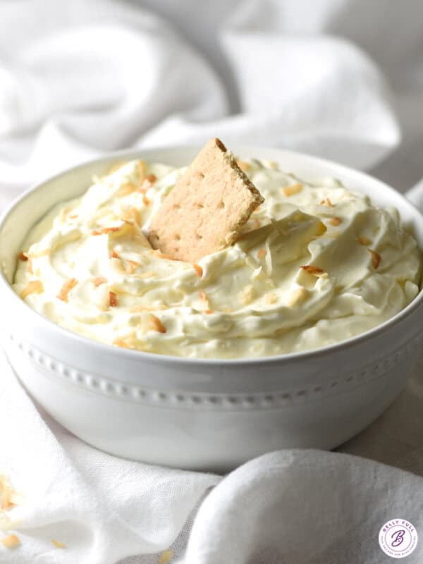 coconut cream pie dip in white bowl with graham cracker