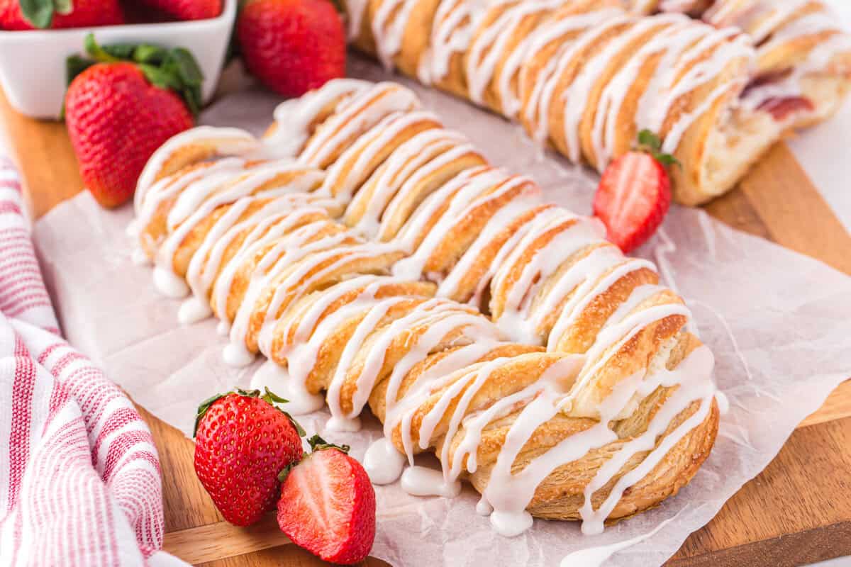 Strawberry cream cheese Danish with frosting and fresh strawberries.