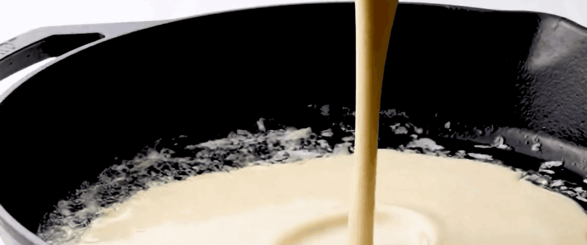 Pouring the batter into a heated skillet.