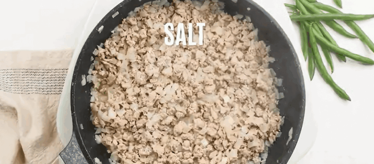 Ground turkey cooking in a black skillet.