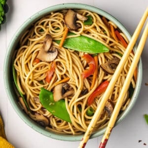 Overhead view of a bowl of veggie lo mein with chopsticks