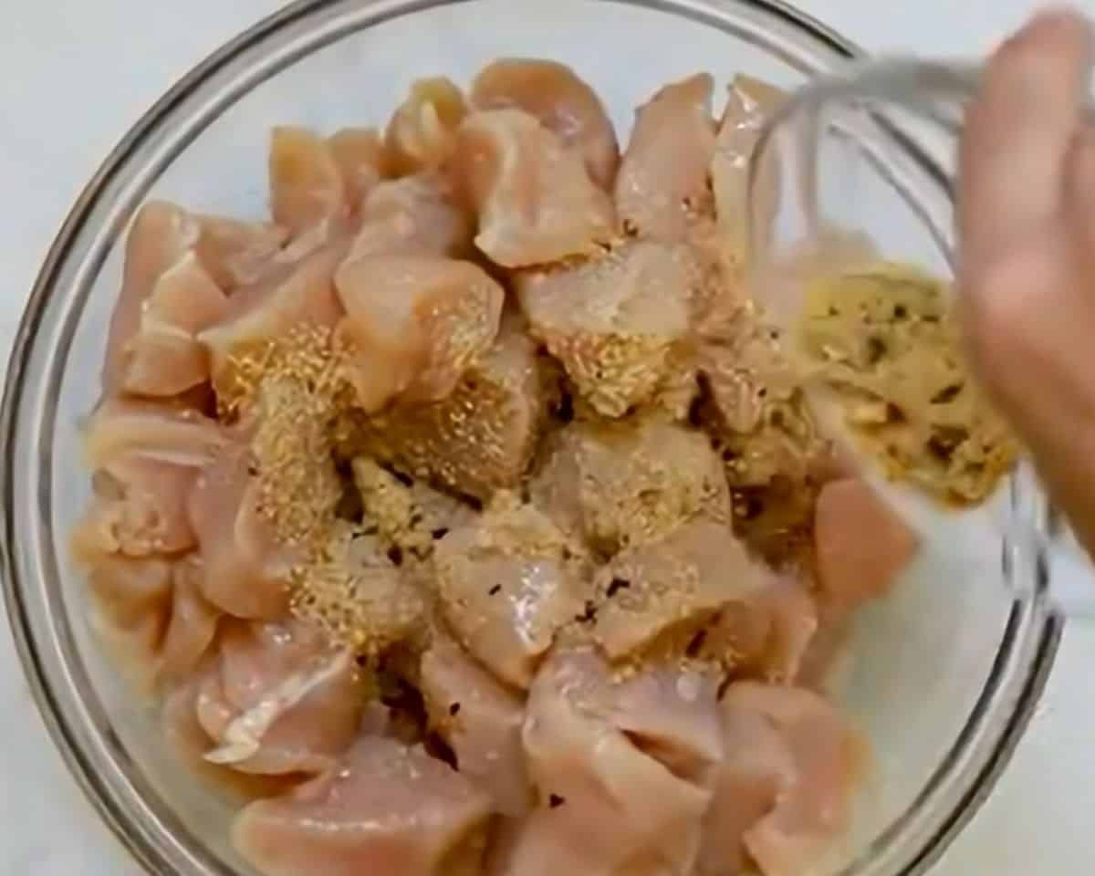 Coating the chicken with the spices.