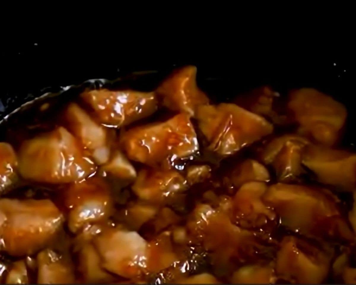 Chicken coated in the sauce in the slow cooker.