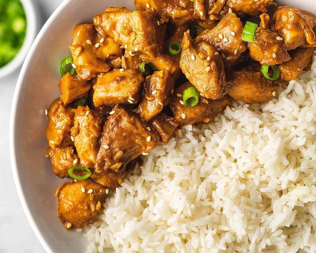 This Slow Cooker Orange Chicken turns your favorite Chinese takeout into an easy weeknight meal. No breading and no frying! Slow cooker orange chicken and rice on a plate.
