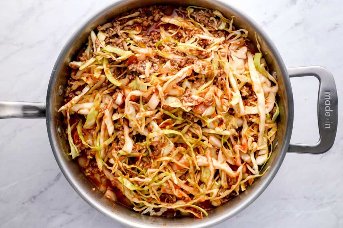 Adding the remaining ingredients to the pot with the ground beef and onions.