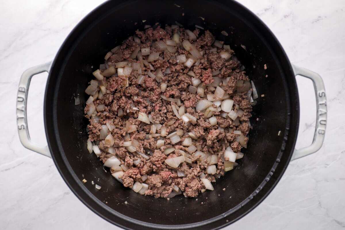 Browning the beef and cooking the garlic and onion.
