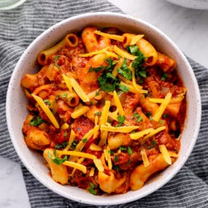 bowl of cooked tomato sauce, beef, macaroni, with shredded cheddar
