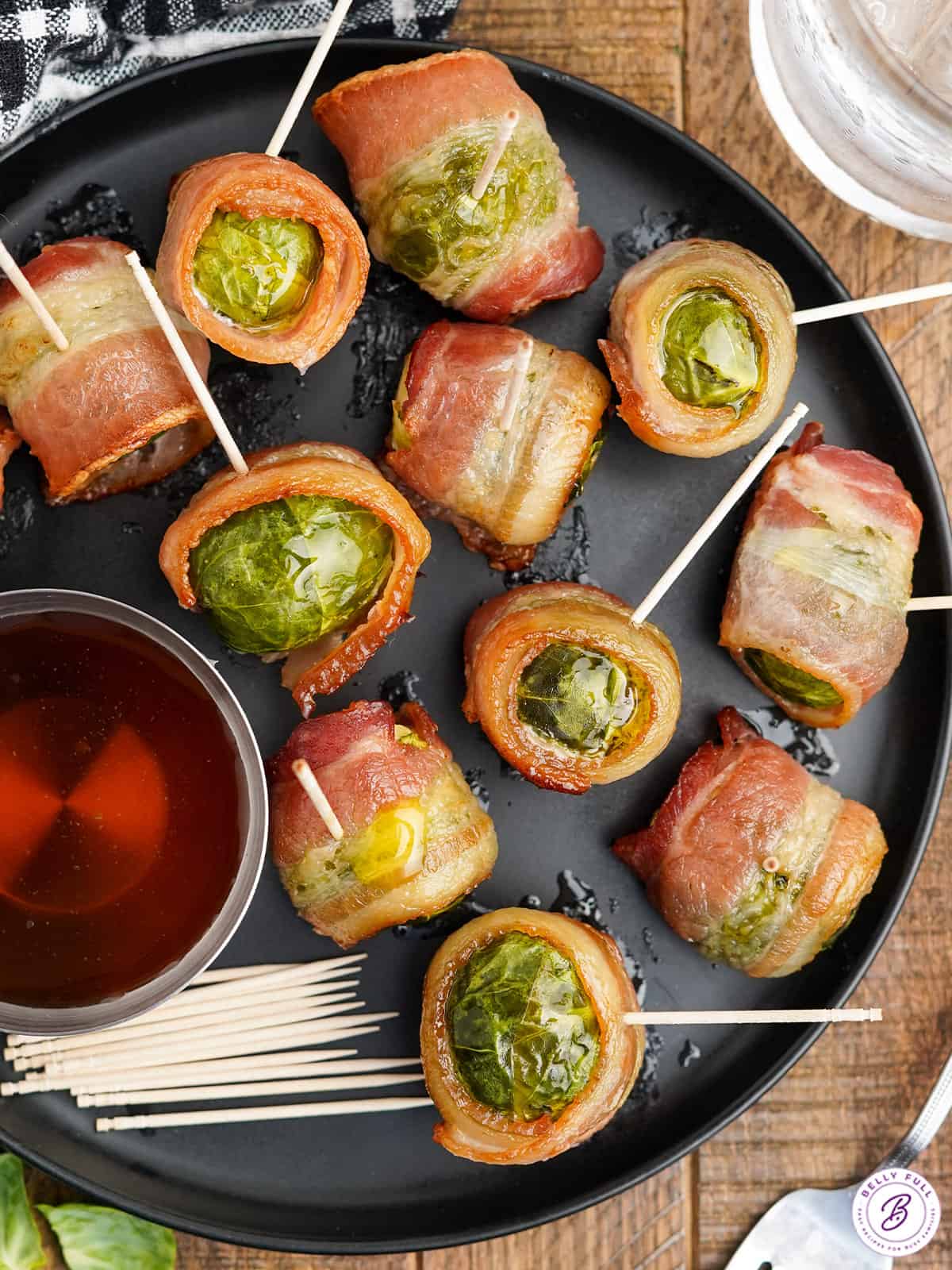 Overhead view of baconw rapped brussels sprouts with a side of maple syrup