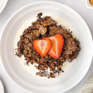 A plate of brownie baked oatmeal with sliced strawberries