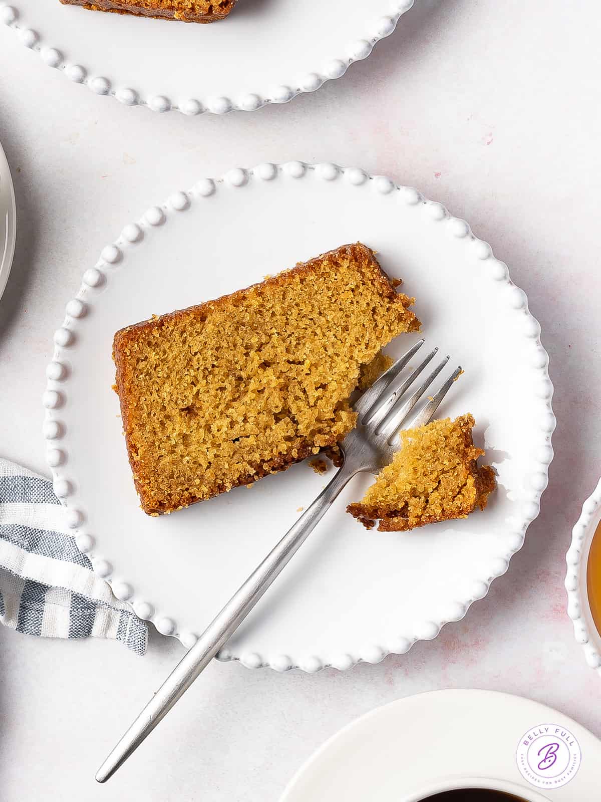 Overhead view of a slice of honey cake on a plate, with a fork