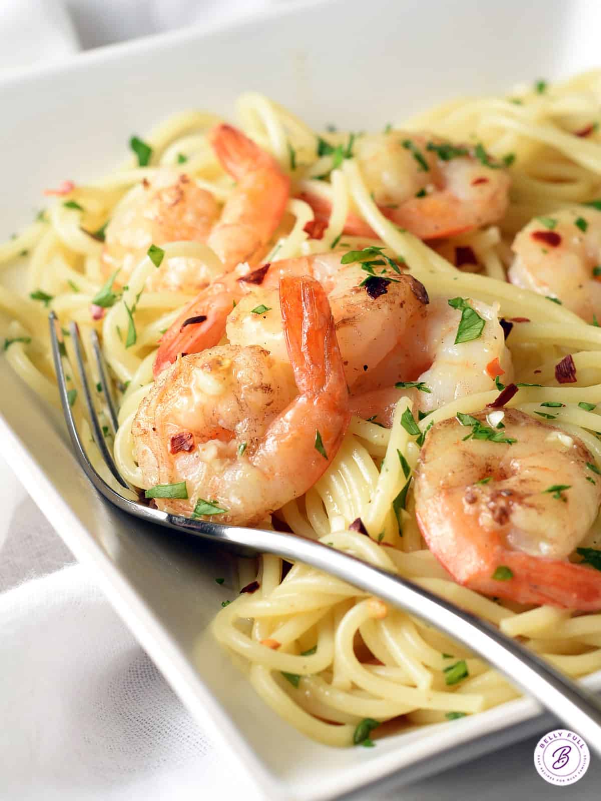 cooked shrimp with tail on over a bed of spaghetti